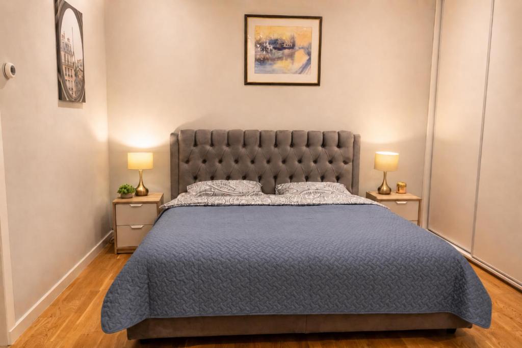 a bedroom with a large bed with two lamps at Unique Mailo House & Cottage in Riga