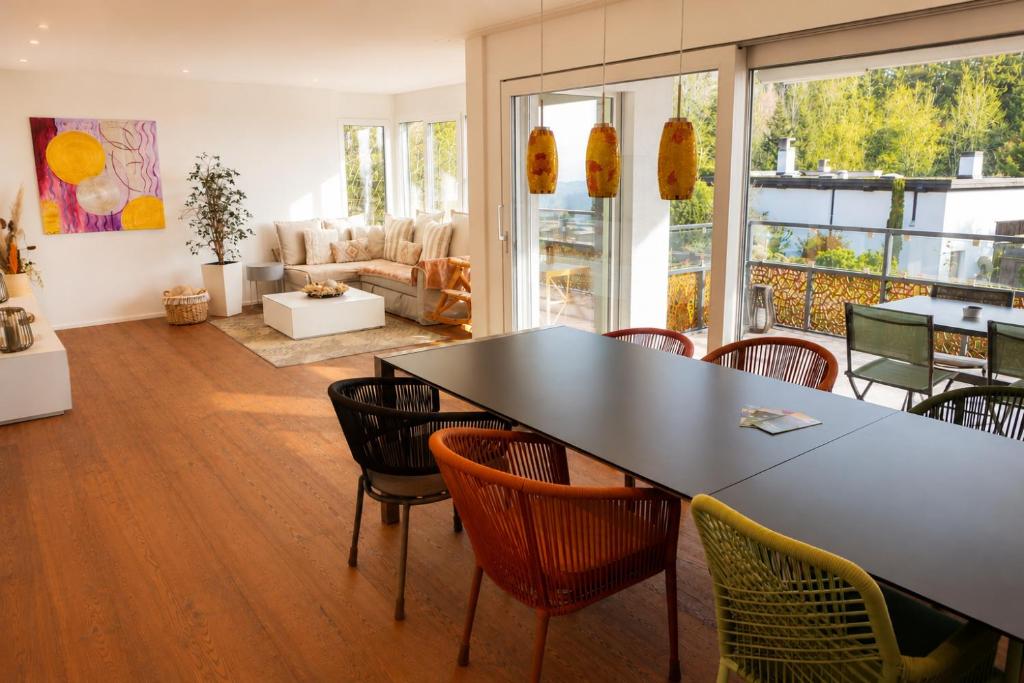a living room with a table and chairs at Swiss Horizon - Mythenblick - Modern 100m2 mit Alpenblick und Terrassen in Hinwil