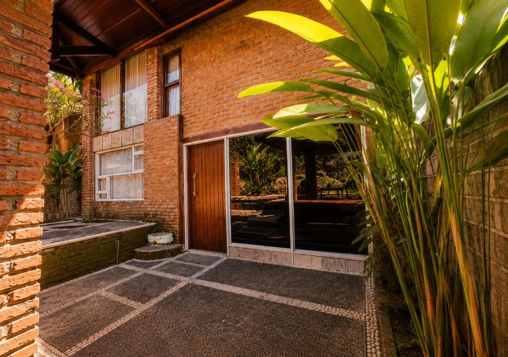 a brick building with a door and a courtyard at Lentera Lombok in Tetebatu