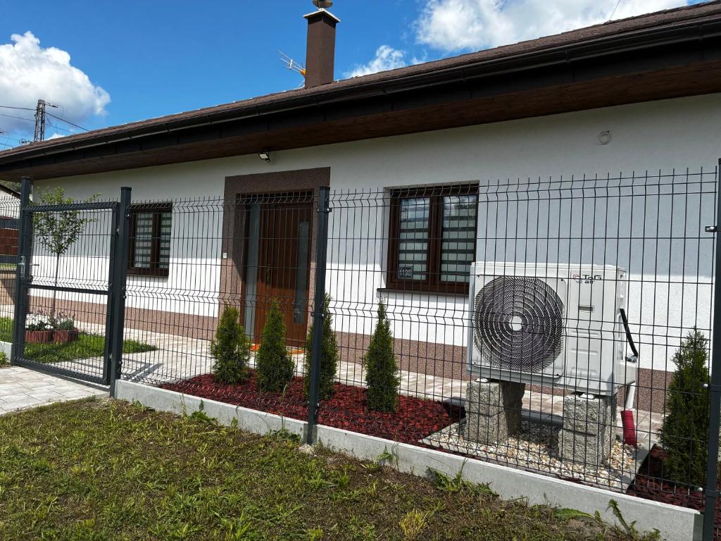 a fence in front of a house with a fan at Prázdninový dům MAJKA in Mosty u Jablunkova