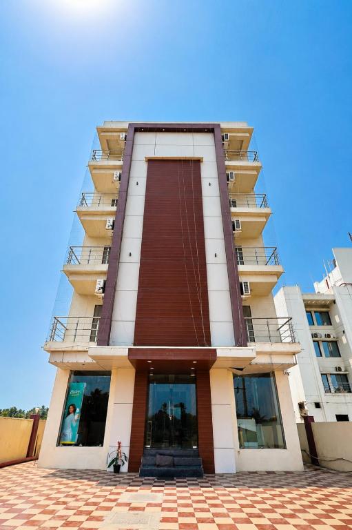 a tall building with a red and white at The Castle Crown - Hotel Scintilla, Somnath in Somnath