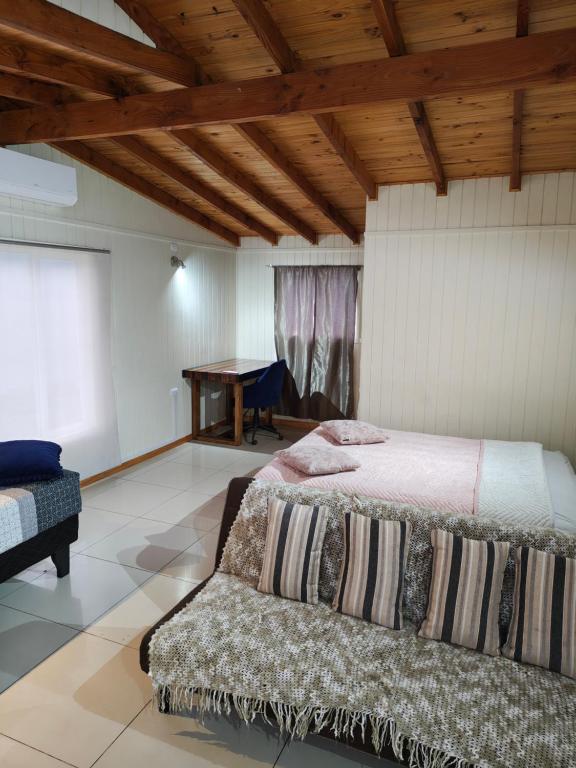 ein Schlafzimmer mit einem Bett und einem Tisch in der Unterkunft dormitorio REST in Chaitén