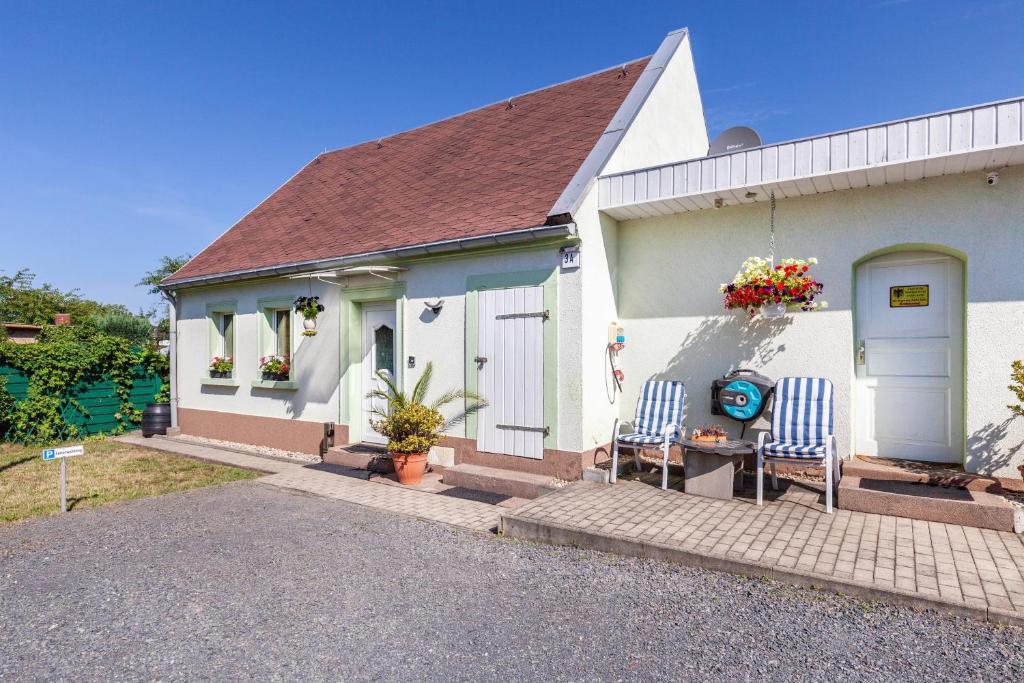 a white house with two chairs in front of it at Ferienwohnung Elbtalblick in Weinböhla