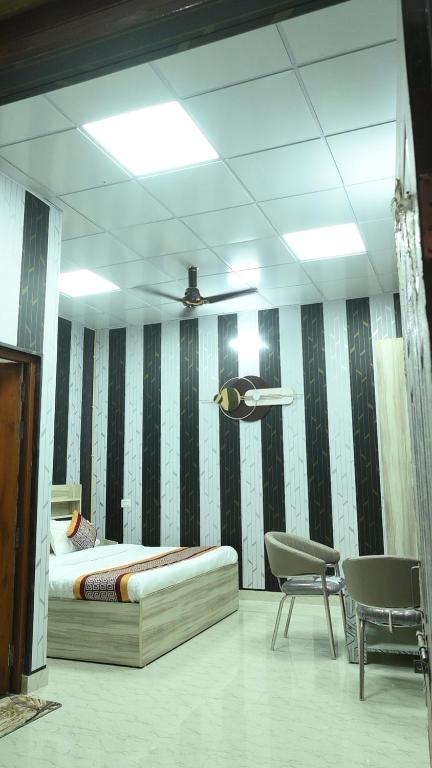 a bedroom with a bed and two chairs and a ceiling at Mansa Lawn & Resort in Lucknow