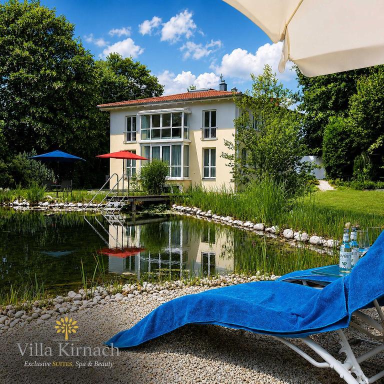 a house with a pond in front of a house at Villa Kirnach Private Spa Retreat im Allgäu in Biessenhofen