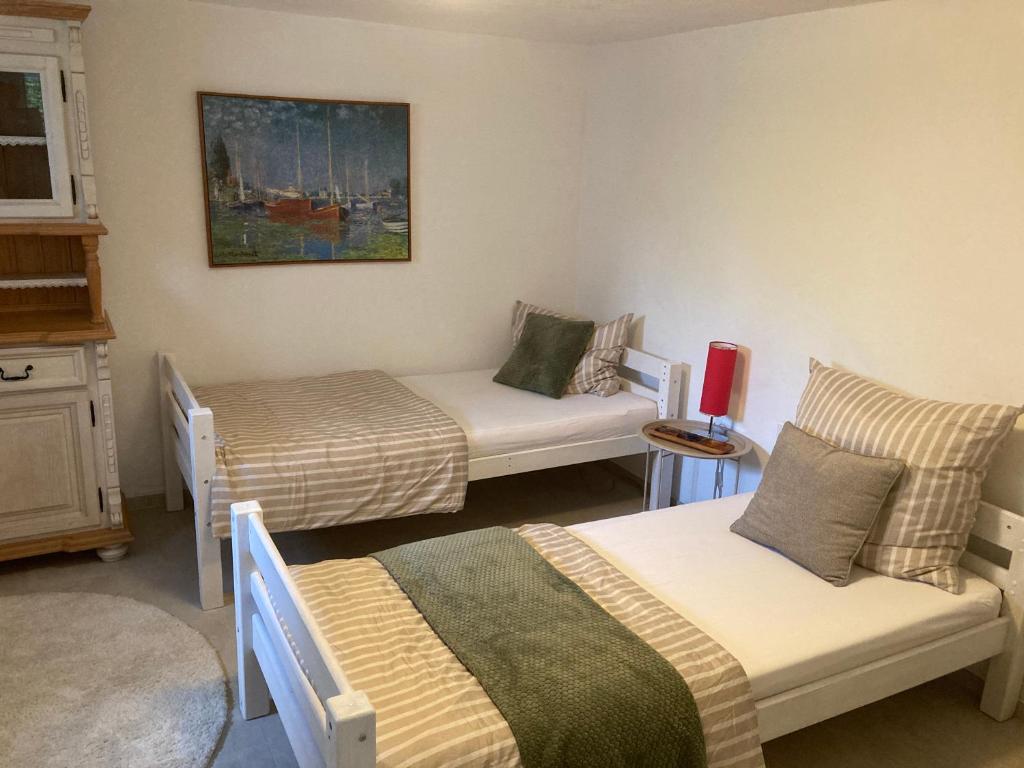 a room with two beds and a table and chairs at Appartement 1 in Wackersdorf