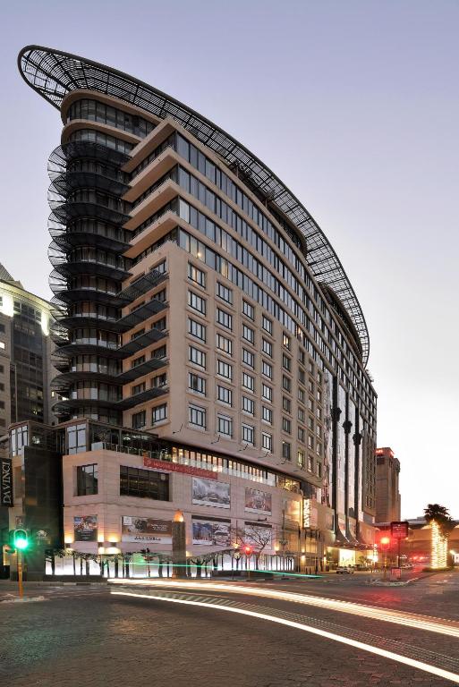 a large building with a curved roof on a city street at DAVINCI Suites in Johannesburg