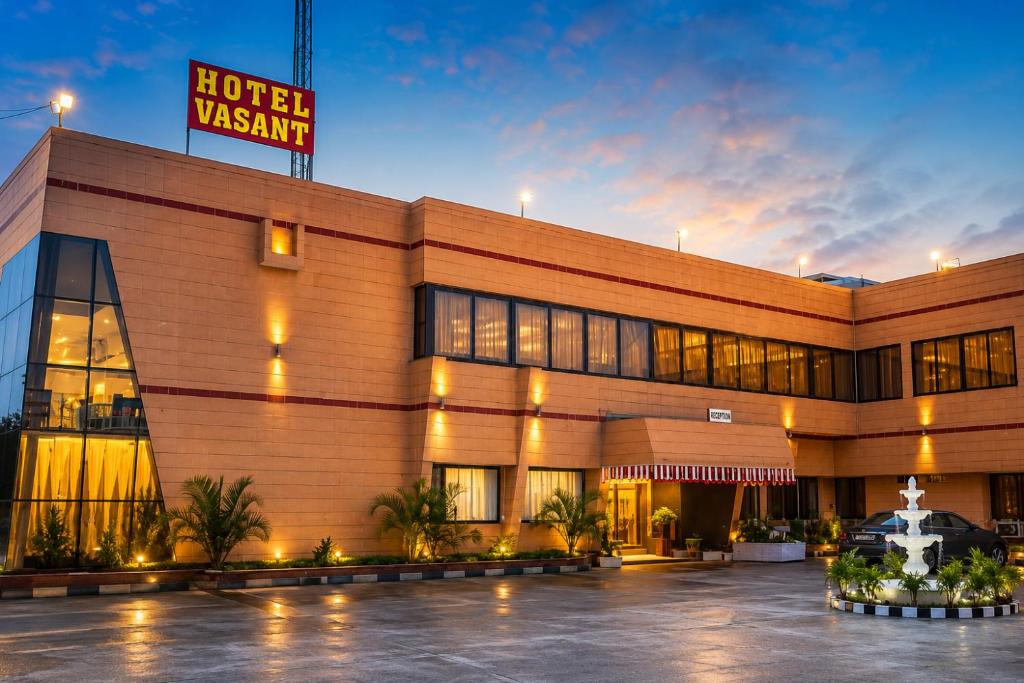 a hotel with a sign in front of a building at Hotel Vasant - Premium Hotel in Gajraula - All AC Rooms with Restaurant - Free Wi-fi & Parking - Banquet in Gajraula