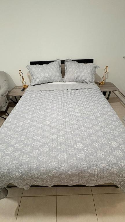 a large bed with a white comforter on it at HollywoodCozyStudio in Hollywood
