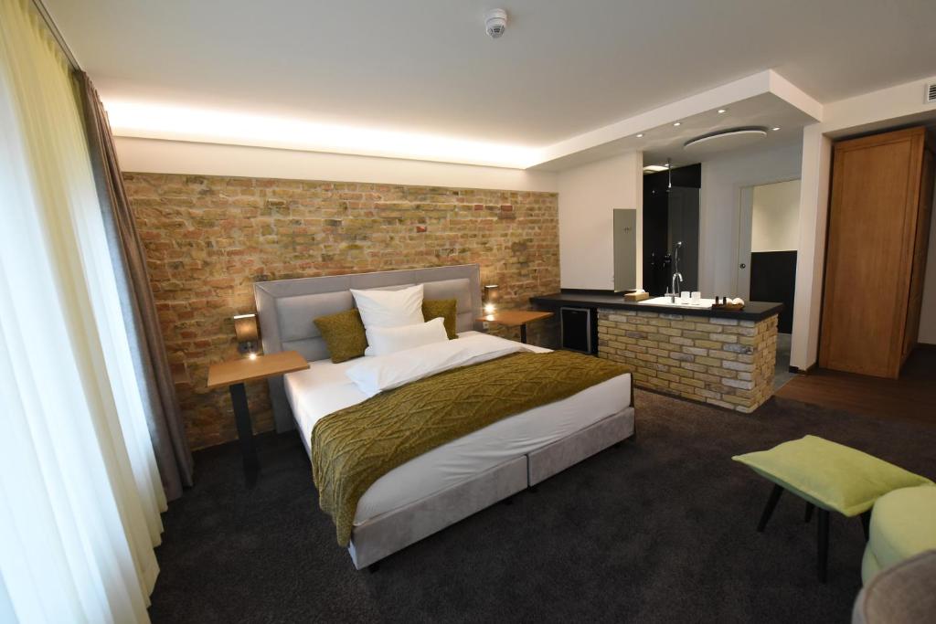 a hotel room with a bed and a brick wall at Höll am Main in Rüsselsheim