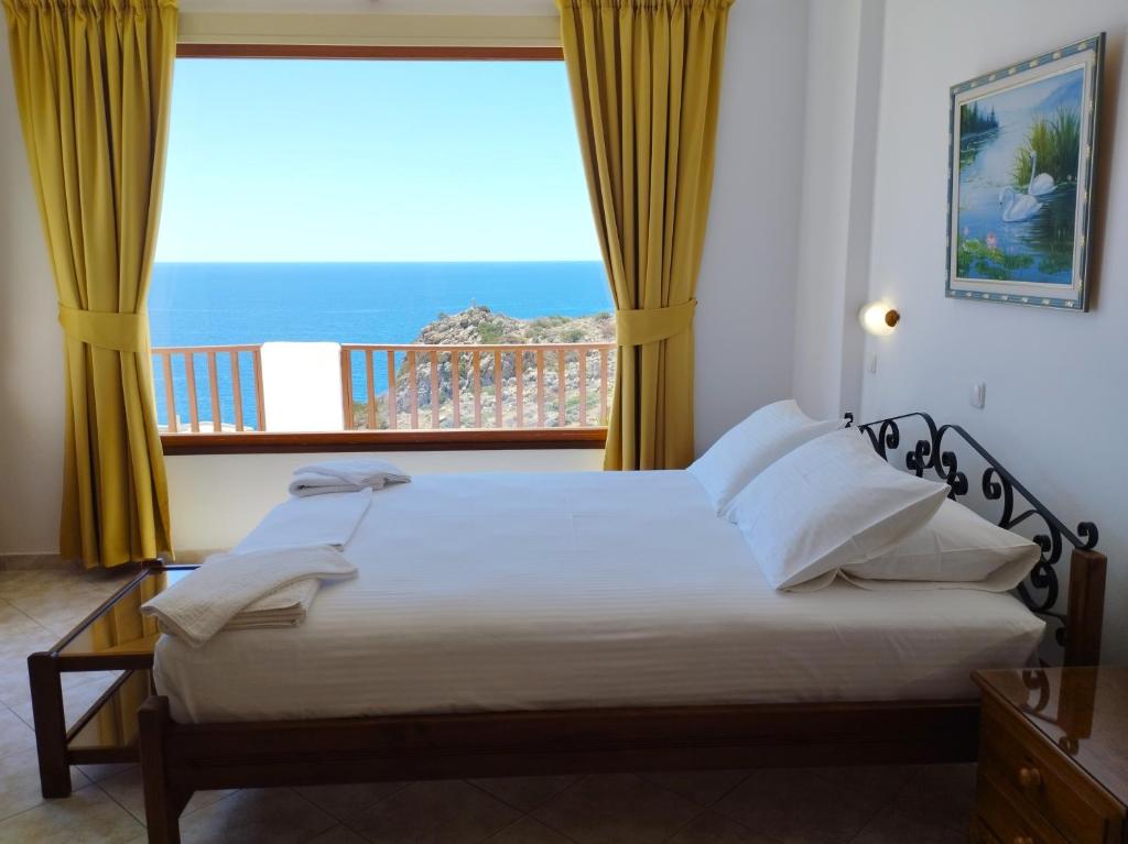 una camera da letto con un letto con vista sull'oceano di Olympos Studios ad Amoopi