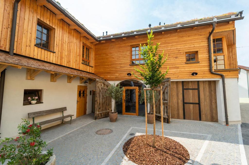 a building with a bench and a tree in the courtyard at Eidenberger's Herberge in Eidenberg