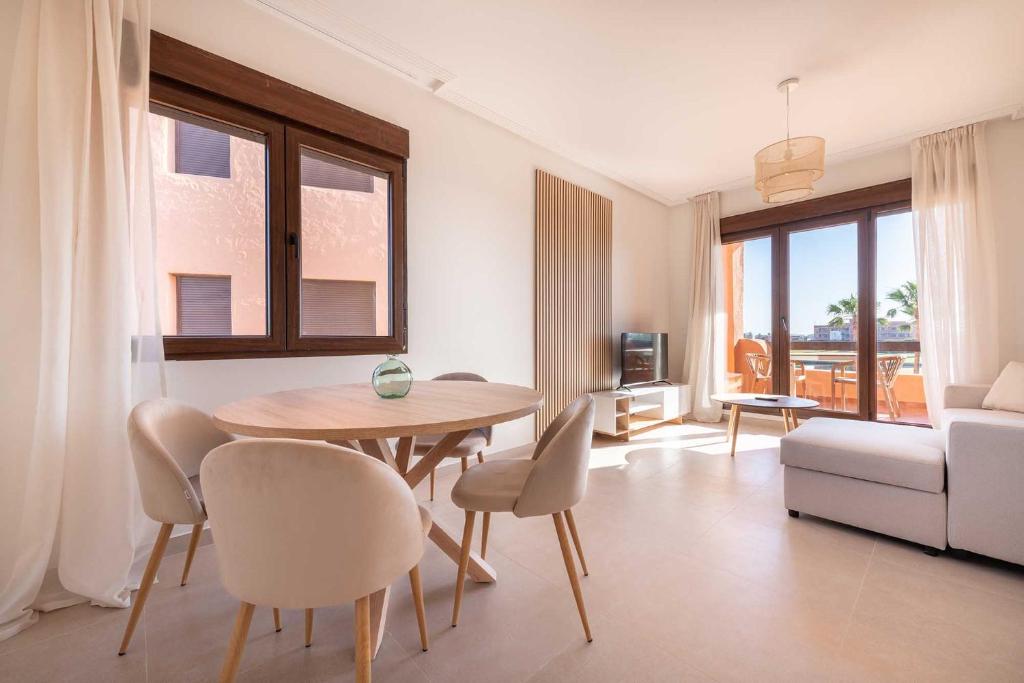 a living room with a table and chairs and a couch at Serena Golf Apartments in Los Alcázares