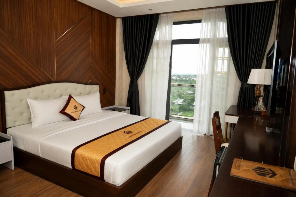 a bedroom with a bed and a large window at Thảo Ngân Pleiku Hotel in Pleiku