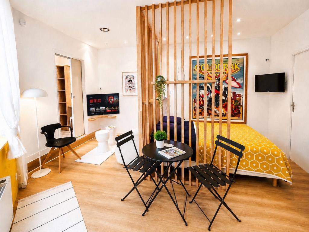 a living room with a table and chairs at Le Goldorak, Hyper-centre, Garage privé, CLIM et canal plus in Niort