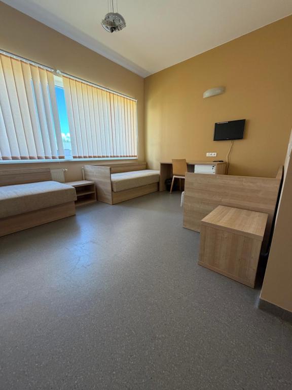 a room with a bed and a table and a tv at Kambarių nuoma in Utena