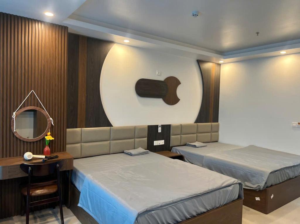 a hotel room with two beds and a mirror at Tâm An Luxury Hotel in Ninh Lão
