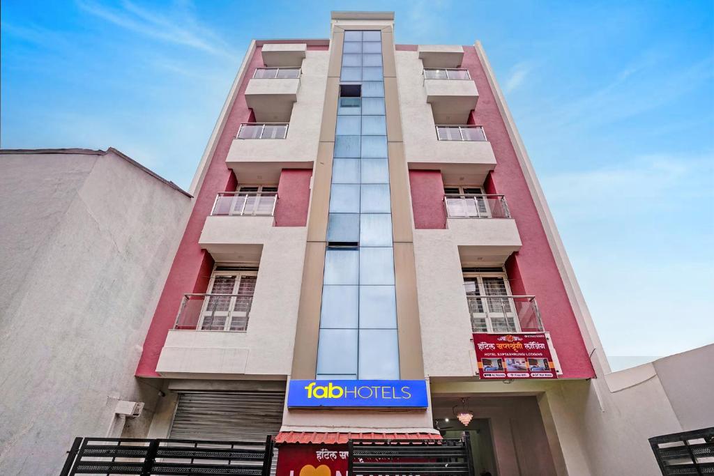 a tall building with aida hotels sign in front of it at FabHotel Saptshrungi in Nashik