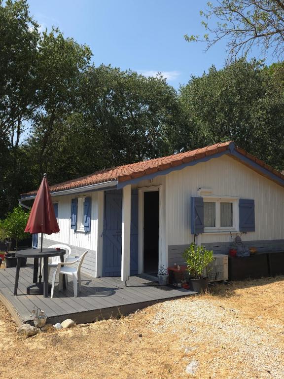 a small white house with a table and a patio at Le chalet de la tranquillité ! in Parignargues