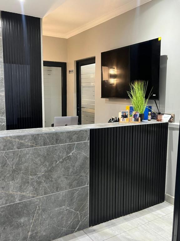 a lobby with a bar with a tv on the wall at Lukholo guest house siyabuswa in Siyabuswa