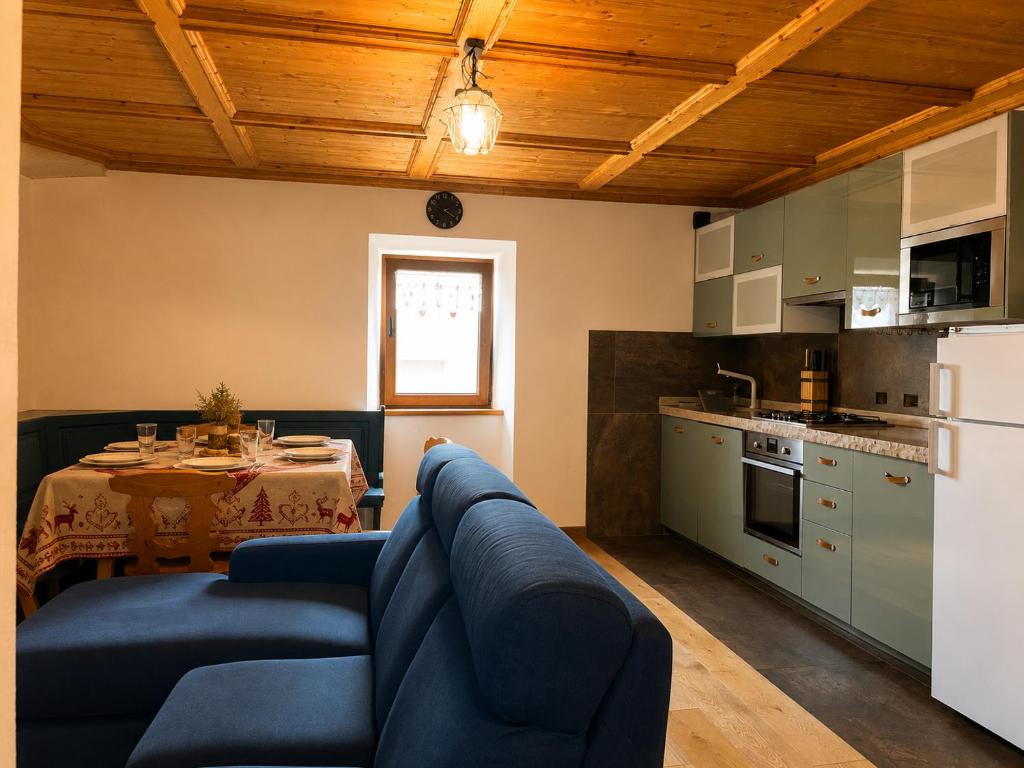 a living room with a blue couch and a table at Alpèa in Lavarone
