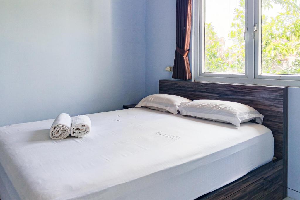 a bed with two pairs of shoes sitting on it at Dprof Exclusive Guesthouse Semarang RedPartner in Jatingaleh