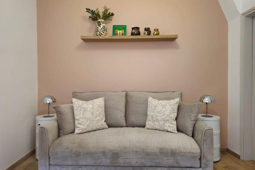 a gray couch in a living room with two lamps at Studio cocooning à 5km du centre de Strasbourg in Schiltigheim