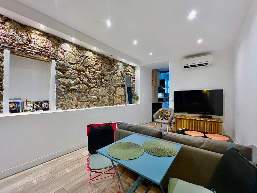 a living room with a couch and a tv at COCON HYPER CENTRE-VILLE TOUT CONFORT (8) in Ajaccio