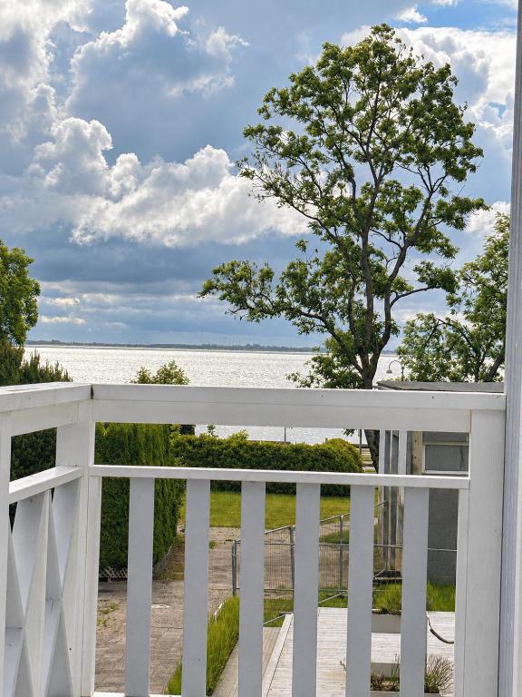 a white porch with a view of the ocean at Marių vilos apartamentai Balcony with a Lagoon View in Juodkrantė