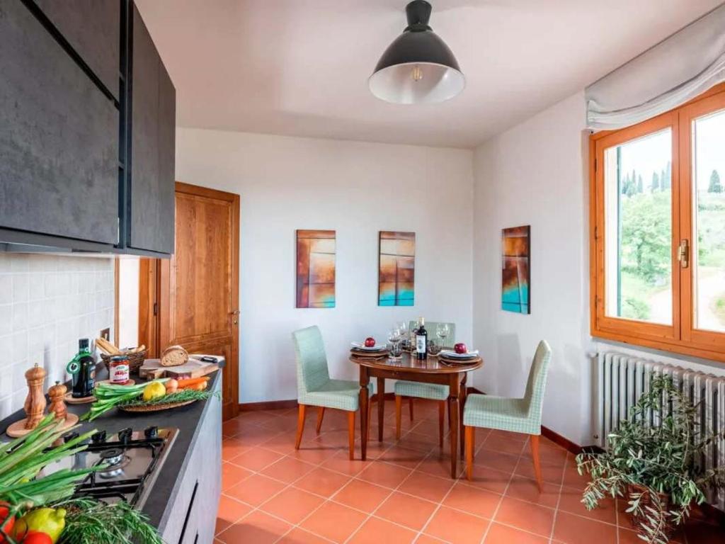 a kitchen with a table and chairs in a kitchen at Apartment Olearum in Panzano