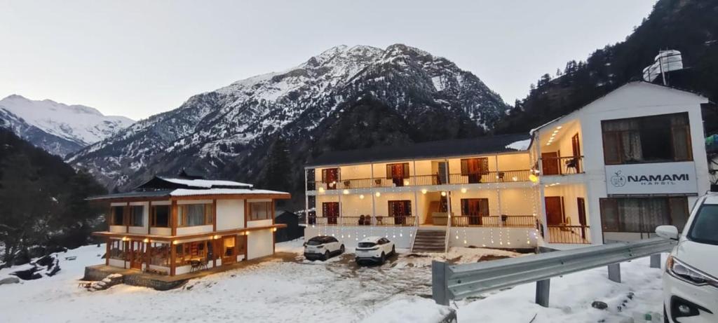 a house in the snow in front of a mountain at Namami Harsil in Harsil
