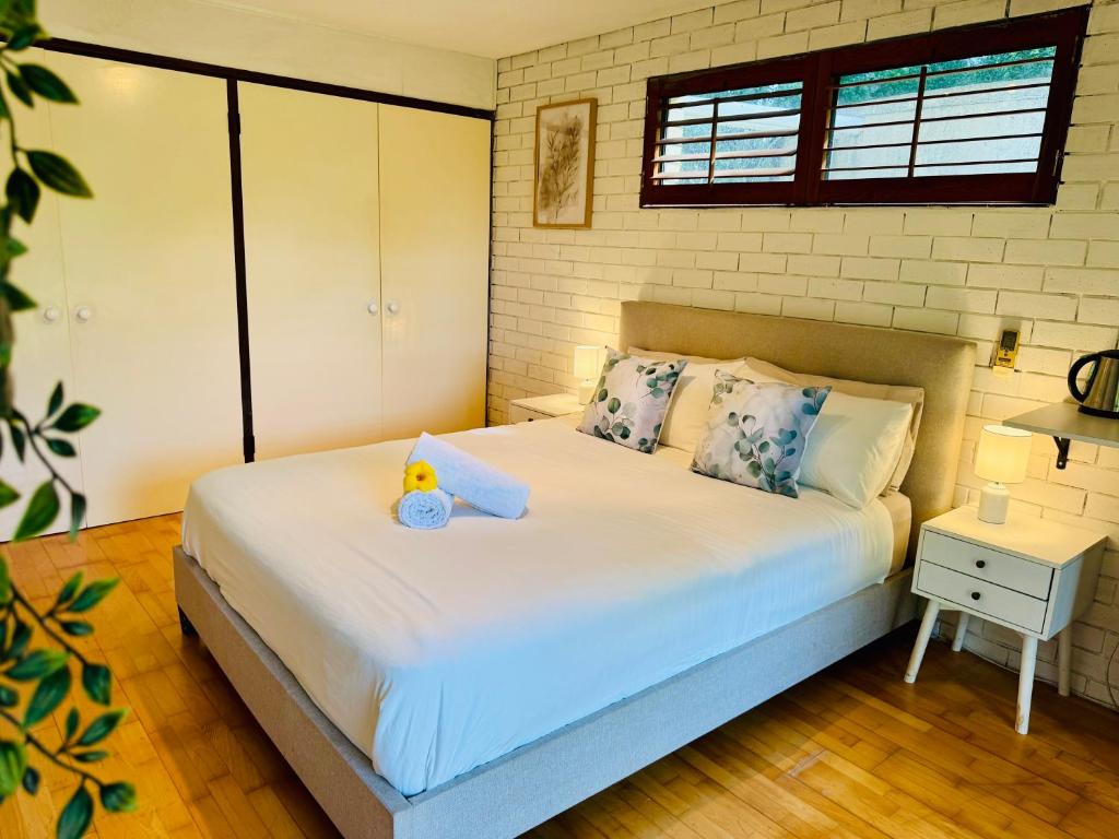 a bedroom with a bed with a teddy bear on it at Garden Studio - Tranquil Forest Retreat in Currumbin Valley