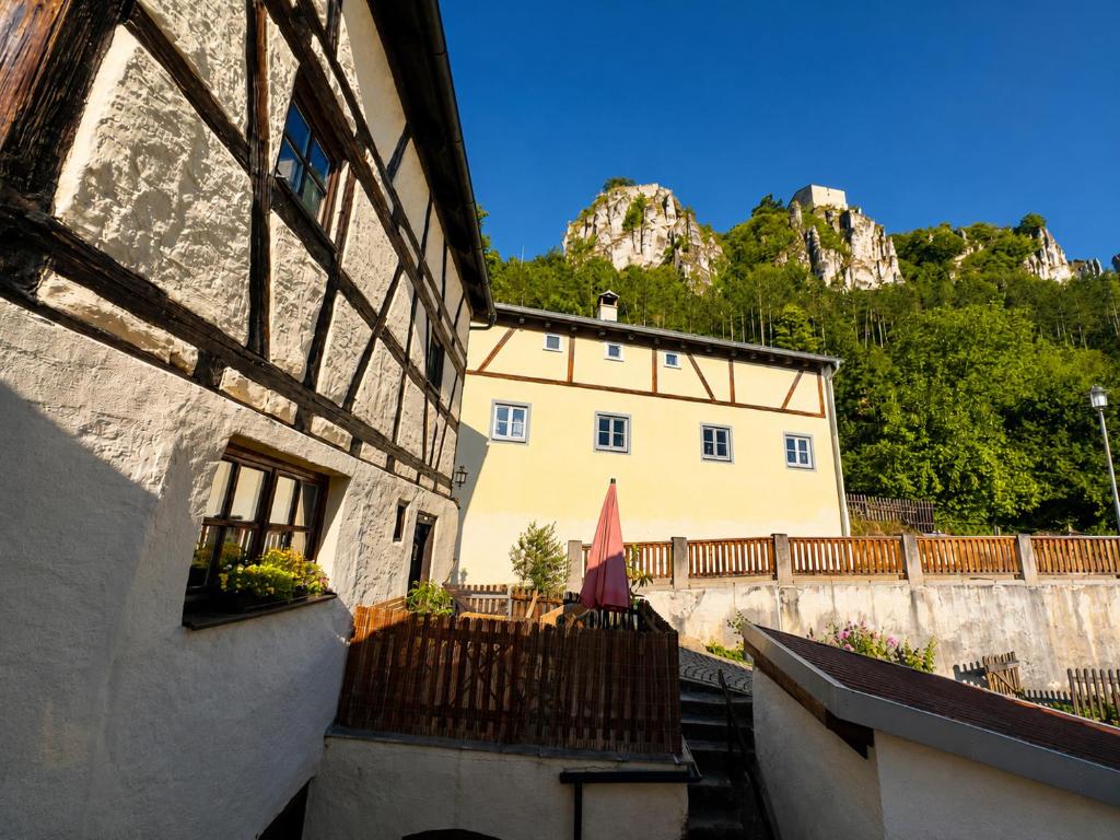a building with a table and an umbrella in front of it at Torwärterhaus Kipfenberg-Arnsberg in Arnsberg