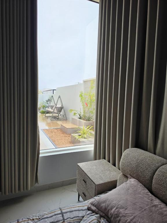 a bedroom with a window with a view of a garden at Ubar-Salalah in Salalah