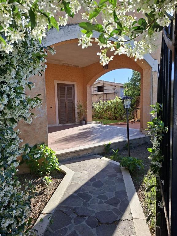 an entrance to a building with an arch with flowers at La Maison D'Amì in Anguillara Sabazia