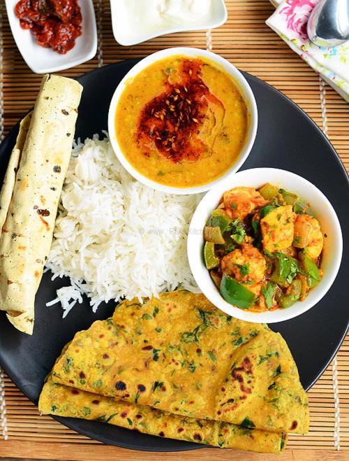 a plate of food with rice and a bowl of soup at NG House in Indore