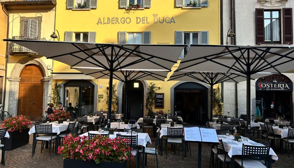 an outdoor restaurant with tables and chairs and umbrellas at Albergo del Duca in Como