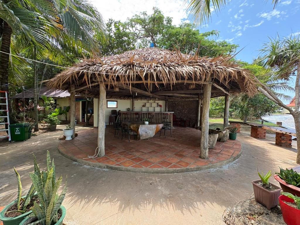 a pavilion with a table and a straw roof at Kep Ocean Inn in Kep