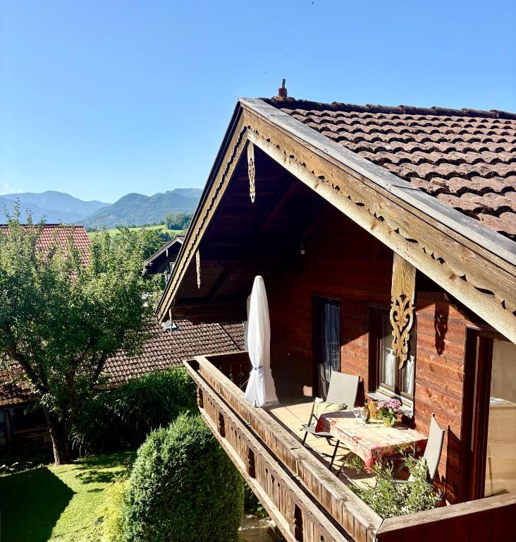 a house with a deck with a table and a umbrella at Apartment Bergblick in Frasdorf