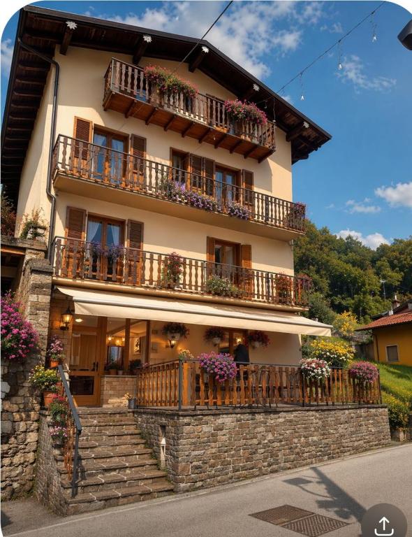 a building with flowers on the balconies and stairs at La Scaletta in San Colombano