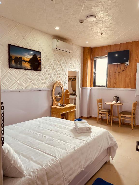 a bedroom with a bed and a table and chairs at Solar Tower in Soc Trang
