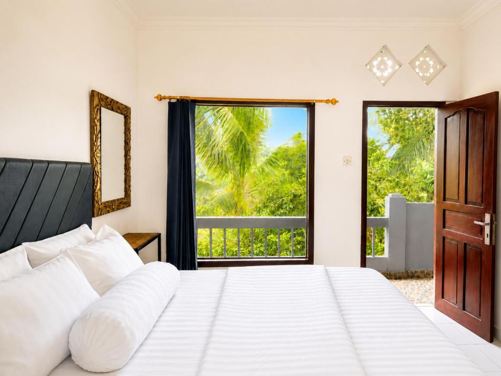 ein Schlafzimmer mit einem großen weißen Bett und einem Fenster in der Unterkunft Buana Asti Homestay Retreat Batukaru in Tabanan