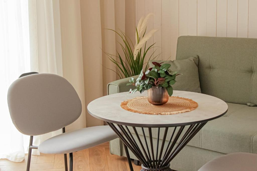 a table with a vase on it in a living room at Sakų Apartamentai in Varėna