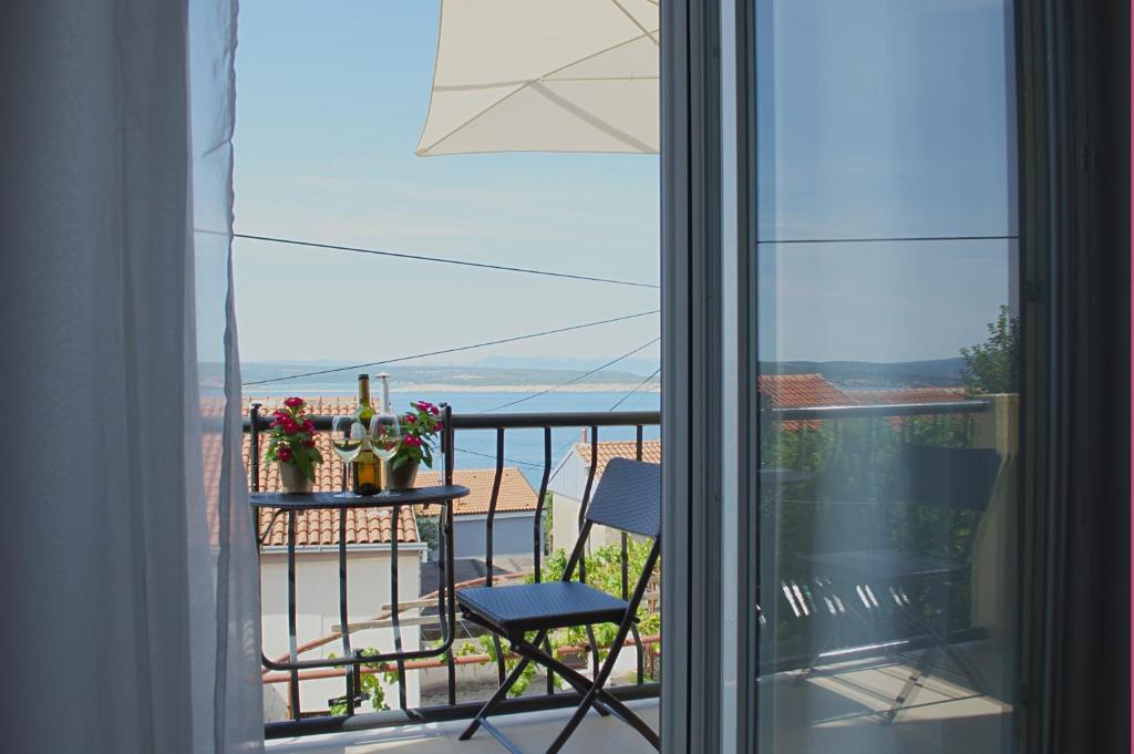 a balcony with a chair and a view of the ocean at Maslina in Crikvenica