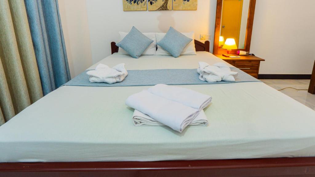 a bedroom with two beds with towels on them at Sayare Inn in Dambulla