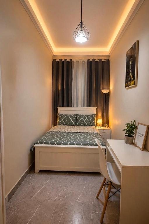 a small bedroom with a bed and a desk at Haven Hub in Abu Dhabi