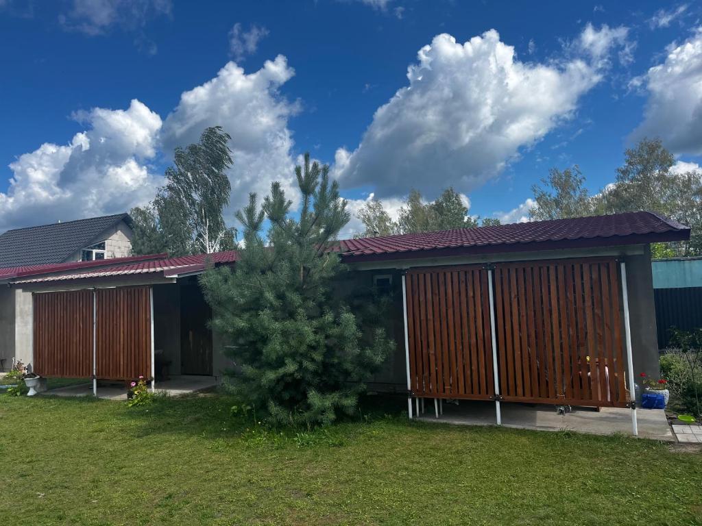 a house with a tree in the yard at Будиночок Перший rio de pulmo in Pulʼmo