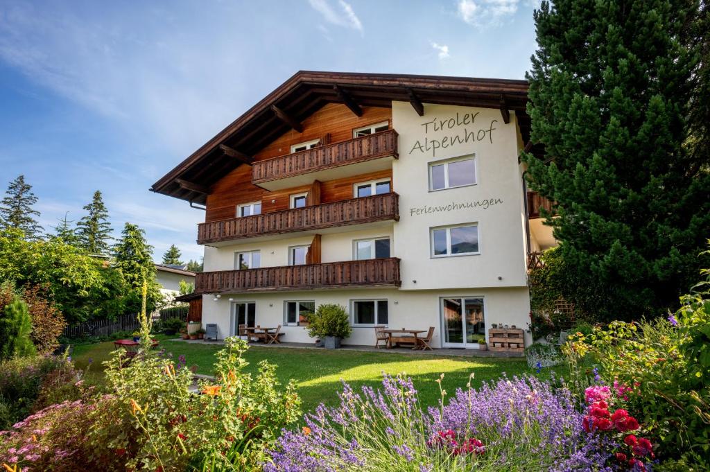 a hotel apartment with a garden and flowers at Ferienwohnungen Tiroler Alpenhof in Innsbruck
