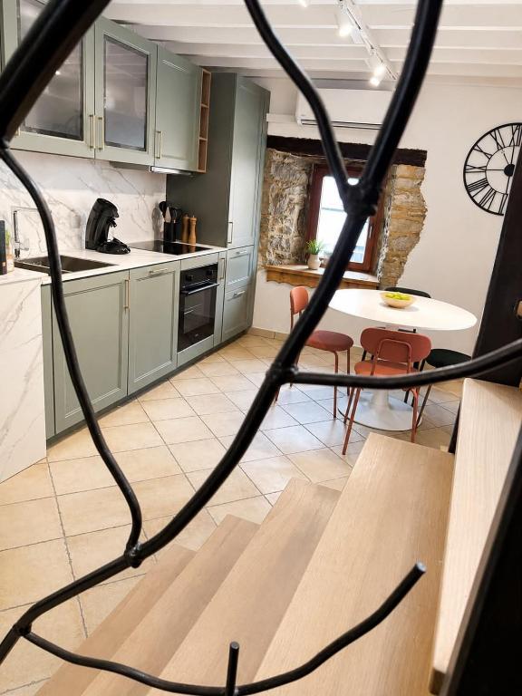 a kitchen with green cabinets and a table and chairs at La Petite Grange in Aywaille