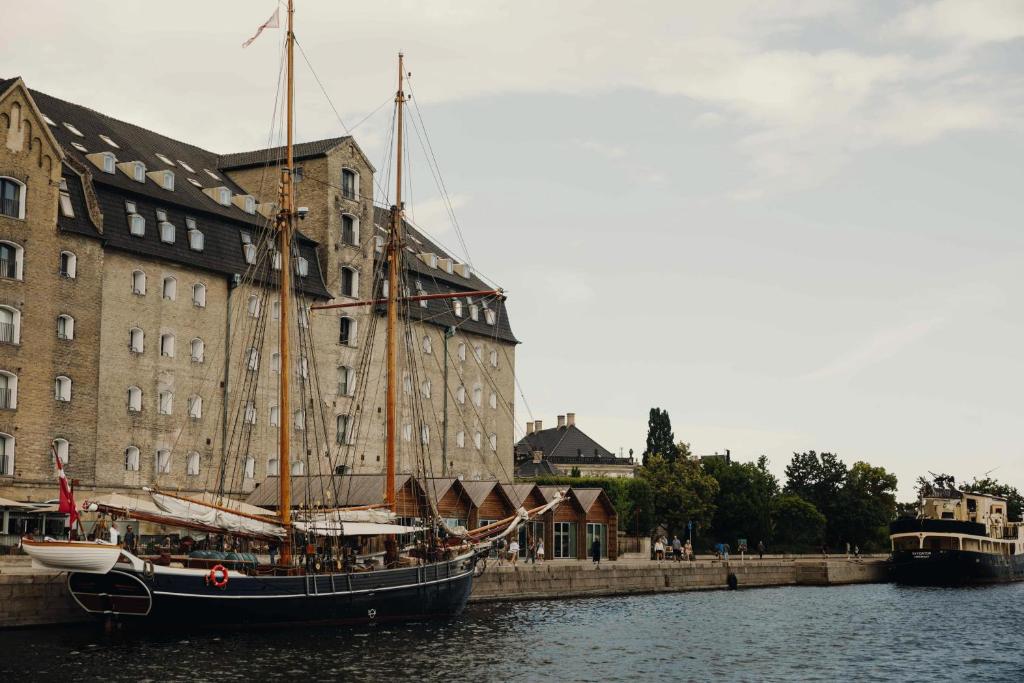 a boat in the water in front of a building at Admiral Hotel Copenhagen in Copenhagen